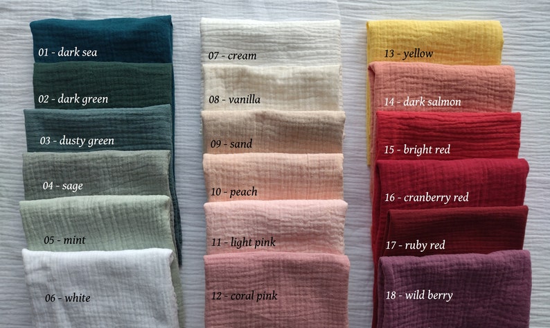 May include: A collection of folded fabric swatches in various colors, including dark sea, dark green, dusty green, sage, mint, white, cream, vanilla, sand, peach, light pink, coral pink, yellow, dark salmon, bright red, cranberry red, ruby red, and wild berry. Each swatch is labeled with a number and color name.