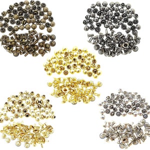 Könnte beinhalten: Sortiment aus Metallnieten in Gold-, Silber- und Bronzetönen. Die Nieten sind in verschiedenen Größen und haben einen abgerundeten Kopf.