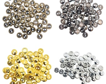 Può includere: Assortimento di bottoni a due fori in oro, argento e bronzo. I bottoni sono piccoli e rotondi, con una finitura liscia.