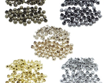 Op de afbeelding: Een verzameling metalen klinknagels gerangschikt in vijf afzonderlijke groepen, met metallic afwerkingen in antiek brons, gunmetal, goud, messing en zilver. Elke groep bestaat uit talloze kleine, ronde bevestigingsmiddelen.