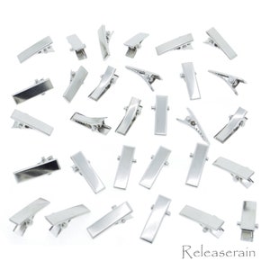 Op de afbeelding: Een set van 30 zilveren alligatorclips. De clips zijn rechthoekig en hebben een gladde, glanzende afwerking.