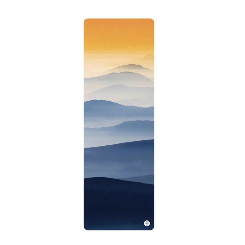 May include: A yoga mat with a blue and yellow mountain landscape design. The mountains are layered and fade into a misty background.
