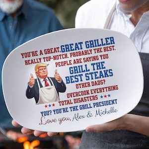May include: White oval platter with text and a cartoon image of a man giving a thumbs up. The text reads "You're a great griller... Grill the best steaks... You're the grill president." The platter is held by a person.