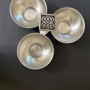 Könnte beinhalten: Eine silberne Servierplatte mit drei Abschnitten und einem dekorativen Design auf dem Mittelstück. Jeder Abschnitt ist eine kleine Schale.