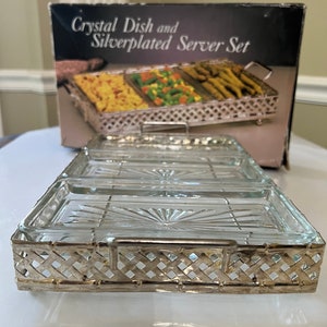 Może przedstawiać: Srebrna taca do serwowania z trzema przezroczystymi szklanymi naczyniami. Taca ma wzór kratowy i uchwyt. Na pudełku widnieje napis "Crystal Dish and Silverplated Server Set".