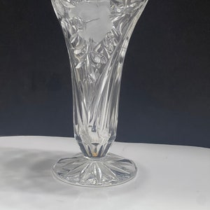 May include: A clear glass vase with a cut crystal design. The vase has a wide mouth and a flared base.