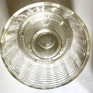 May include: A clear glass bowl with a fluted design. The bowl has a raised center base.