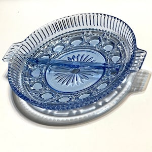 Op de afbeelding: Een gedeeld serveerschaal gemaakt van blauw glas met een decoratief patroon. De schaal heeft twee secties en een ingebouwde scheiding.
