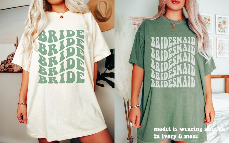 May include: Two short-sleeve t-shirts. The left shirt is ivory with the word BRIDE repeated five times in a wavy, sage green font. The right shirt is moss green with the word BRIDESMAID repeated five times in a wavy, off-white font.