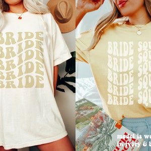 May include: Two short-sleeved t-shirts in ivory and butter yellow. The ivory shirt features the word BRIDE repeated five times in a wavy, stacked font. The butter yellow shirt features the words BRIDE SQUAD in a wavy, stacked font.