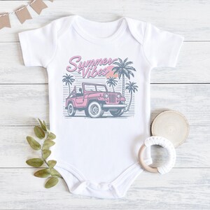 Puede incluir: Un body blanco para beb&eacute; con un jeep rosa y palmeras. El body tiene el texto "Summer Vibes" en rosa y azul.