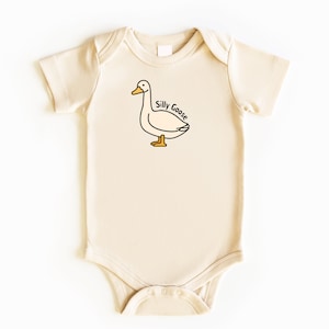 May include: A cream-colored baby onesie with a cartoon goose illustration and the text "Silly Goose" printed on the front.