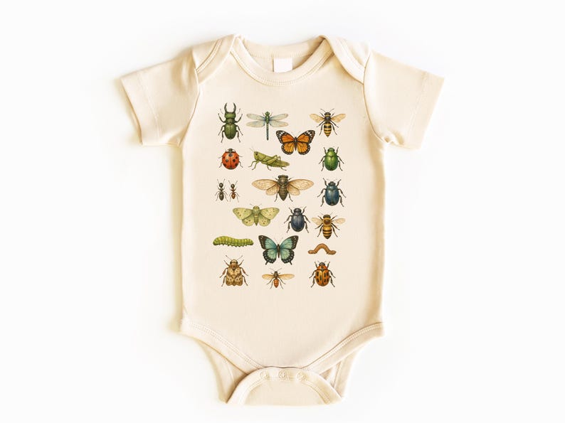 May include: Cream-colored baby onesie featuring a colorful insect illustration. The design includes various bugs like butterflies, beetles, and dragonflies. The onesie has short sleeves and a snap closure at the bottom.