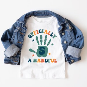 May include: White t-shirt with a colorful graphic that says "Officially 5 A Handful". The graphic features a green handprint with the number 5 inside.