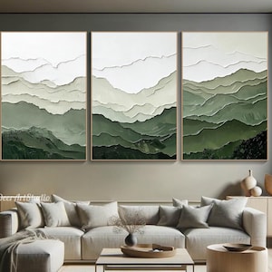 May include: Three framed artworks depicting a layered mountain landscape in shades of green and white. The art has a textured appearance, with the mountains in varying shades of green. The frames are a warm brown colour.