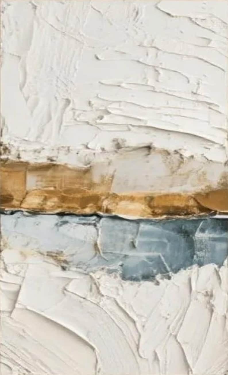 May include: Abstract textured art piece with a rectangular shape. The artwork features layers of white, gold, and blue-gray colors, applied with thick brushstrokes, creating a tactile, three-dimensional effect. The piece has a modern, minimalist aesthetic.