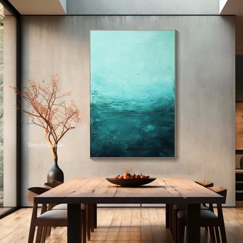 Puede incluir: Pintura abstracta con un degradado de color turquesa y azul. La pintura est&aacute; enmarcada en un marco dorado y est&aacute; colgada en una pared en un comedor moderno.