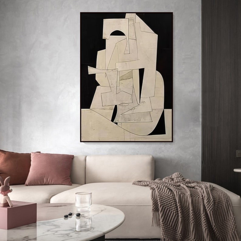 May include: Abstract art print with geometric shapes in white and black on a cream background. The print is framed and hanging on a wall.