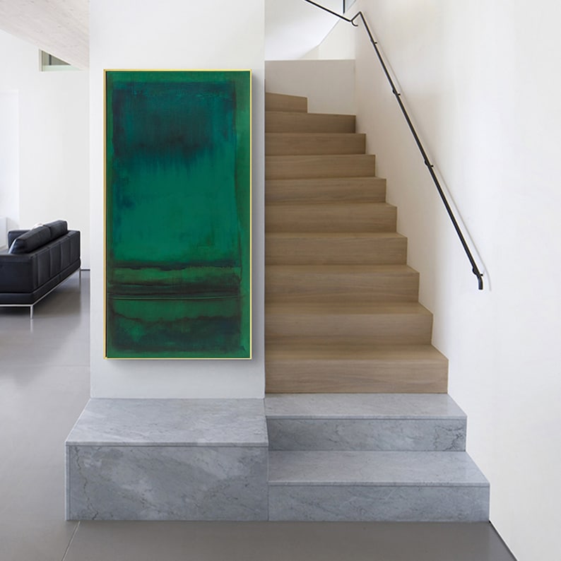 Puede incluir: Pintura abstracta en tonos verdes, enmarcada en oro, colgada en una pared blanca sobre un conjunto de escaleras de m&aacute;rmol.