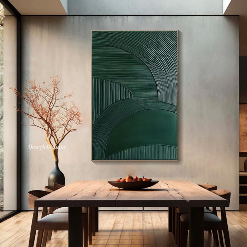 May include: A framed abstract wall art piece with a textured, dark green design. The artwork features curved and linear patterns, creating a layered effect. The piece is displayed in a modern dining room setting.