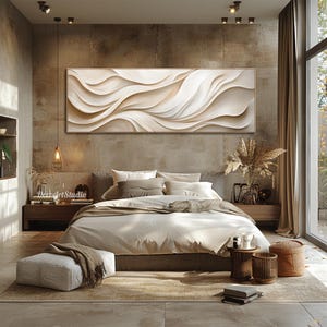 May include: A bedroom interior with a large abstract wall art piece featuring white and beige wavy lines. The bed is made with white bedding and a brown throw blanket. There are two small side tables with decorative items on them.