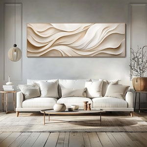 May include: A large abstract painting with flowing white and beige lines, hanging above a white sofa with beige pillows in a living room setting.