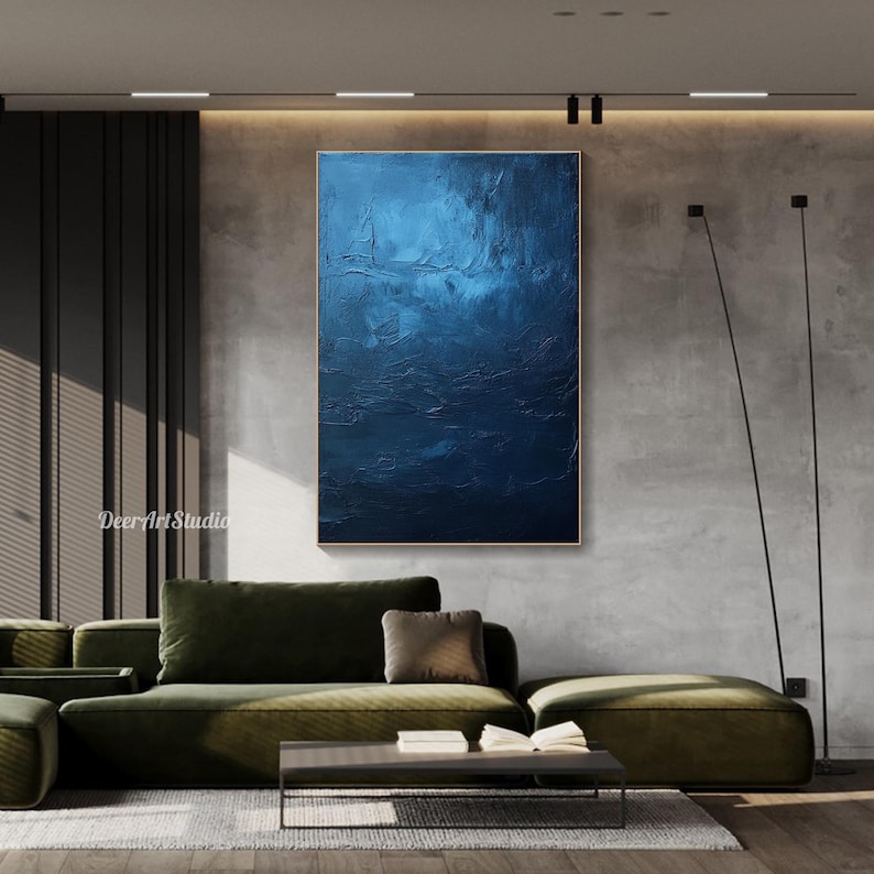Puede incluir: Pintura abstracta en tonos azules con un efecto texturizado y en capas. La pintura se muestra en una pared en un ambiente de sala de estar moderna.