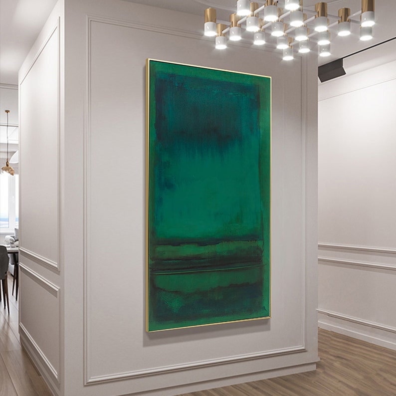 Puede incluir: Pintura abstracta con un esquema de color verde y azul. La pintura est&aacute; enmarcada en oro y cuelga de una pared blanca.