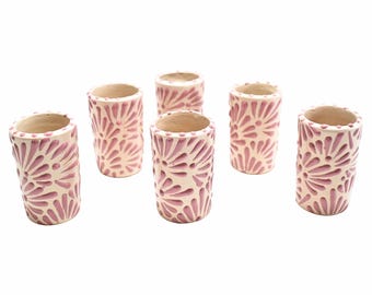 Puede incluir: Juego de seis pequeñas tazas de cerámica blanca con un diseño floral rosa. Las tazas son de forma cilíndrica y tienen un acabado liso y mate.