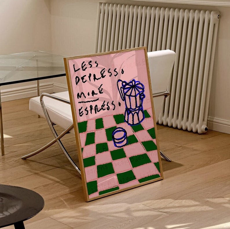 May include: A framed print with a pink background and a green and pink checkered pattern. The print features a blue and white illustration of a coffee pot and a cup, with the text "Less Depresso More Espresso" written in blue.