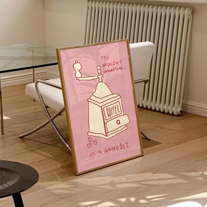 May include: A pink and white framed illustration of a coffee grinder with the text "YOU WOULDN'T UNDERSTAND... IT'S A GRIND SET." and the words "COFFEE" and "basic Bdesigns" repeated throughout the image.