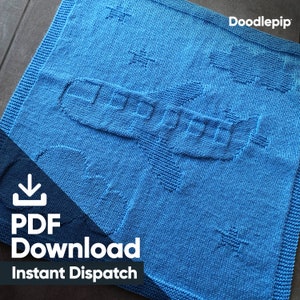 Könnte beinhalten: Eine blaue gestrickte Babydecke mit einem weißen Flugzeugmuster. Die Decke hat einen Download-Button und den Text "PDF Download Instant Dispatch" in der linken unteren Ecke.