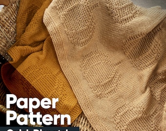 May include: Two knitted blankets in a wicker basket. One blanket is mustard yellow and the other is beige. The text "Paper Pattern Quick Dispatch" is on the image.