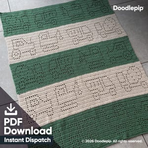 May include: A rectangular crochet blanket featuring alternating horizontal stripes of forest green and cream yarn. The design incorporates openwork lettering that spells out the phrase "BE KIND" repeatedly across the entire surface of the textile.