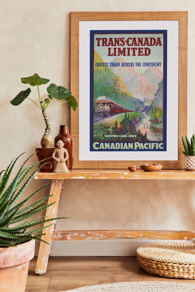 May include: A framed vintage travel poster for the Trans-Canada Limited train, featuring a red train traveling through a mountain landscape. The poster includes the text "Fastest Train Across the Continent" and "Canadian Pacific."