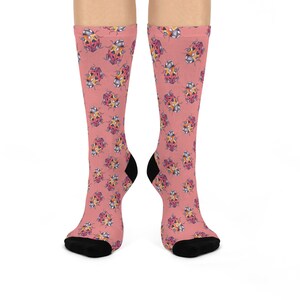 May include: A pair of pink socks with a repeating pattern of colorful ladybugs. The socks are made of a soft, comfortable material and are perfect for everyday wear.