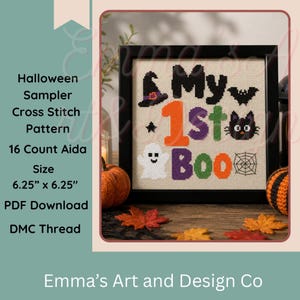 May include: A framed cross stitch sampler on beige fabric featuring the text My 1st Boo in black, orange, purple, and green. The design includes a witch hat, bat, cat, ghost, and spider web. The finished piece measures 6.25 inches by 6.25 inches.