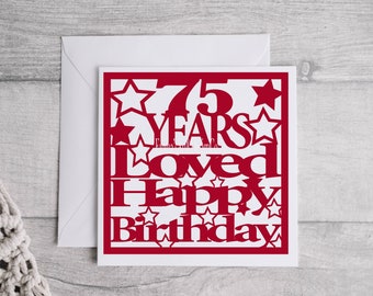 May include: Red card with a white background and the text "75 Years Loved Happy Birthday" in a decorative font with stars.