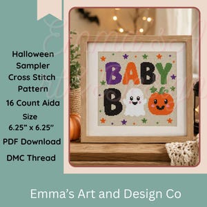 May include: A framed cross stitch sampler on 16 count Aida fabric measuring 6.25 inches by 6.25 inches. The design features the text BABY BOO in purple, orange, black, and green, accompanied by a white ghost and an orange pumpkin graphic.