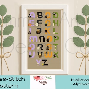 May include: A framed cross-stitch pattern featuring a Halloween alphabet. Each letter is decorated with spooky icons like bats, ghosts, and pumpkins. The letters are in black, orange, and purple. The image is flanked by green leaf stems.