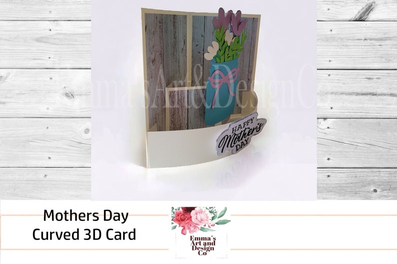 May include: A 3D pop-up card with a curved design. The card features a blue mason jar with pink and white flowers and a wooden background. The card says "Happy Mother's Day".