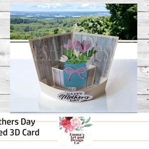 May include: A 3D pop-up card with a rustic woodgrain background. The card features a blue mason jar with pink and white flowers and a "Happy Mother's Day" message.