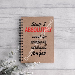 May include: A brown notebook with a spiral binding. The notebook has the text "Stuff I ABSOLUTELY need to remember but probably will forget" written on it.