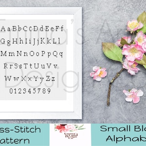 May include: A framed cross-stitch pattern featuring a small block alphabet and numbers. The letters and numbers are in black. The image includes a sprig of pink flowers and the text "Cross-Stitch Pattern" and "Small Block Alphabet".