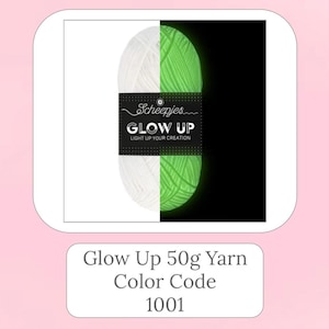 Puede incluir: Una bola de hilo blanco y verde que brilla en la oscuridad. El hilo está etiquetado como "Scheepjes Glow Up Light Up Your Creation".