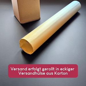 May include: A light yellow paper roll positioned diagonally next to a small brown cardboard box. A red rectangular graphic overlay at the bottom contains the white text: Versand erfolgt gerollt in eckiger Versandh&uuml;lse aus Karton.