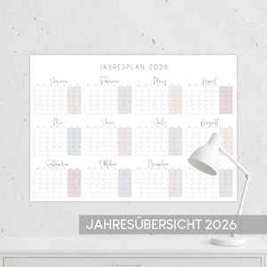 Könnte beinhalten: Ein großer weißer Wandkalender für das Jahr 2026, wobei jeder Monat in einem Rasterformat angezeigt wird. Der Kalender hat ein minimalistisches Design mit Pastellfarben. Der Text "JAHRESPLAN 2026" steht oben und "JAHRESÜBERSICHT 2026" unten.