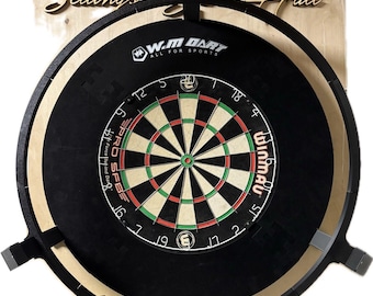 Könnte beinhalten: Eine schwarze Dartscheibe mit einem weißen Bullseye und roten und grünen Segmenten. Die Dartscheibe ist an einer schwarzen und braunen Wandhalterung montiert. Die Dartscheibe ist mit "Winmau" und "Pro SFB" beschriftet. Der Text "Sellinos Hall" ist an der Wand hinter der Dartscheibe sichtbar.