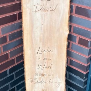 May include: A wooden sign with the names "Patrycja" and "David" written in cursive, with an infinity symbol between them. The sign also has the text "Liebe ist nur ein Wort bis jemand dir die Bedeutung zeigt."