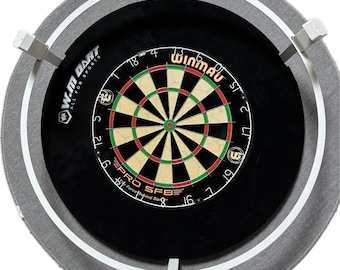 May include: A grey dartboard surround with a white trim and four white brackets. The dartboard is black with a red and green bullseye and the text "Winmau" in red. The text "Pro SFB" is printed below the bullseye.